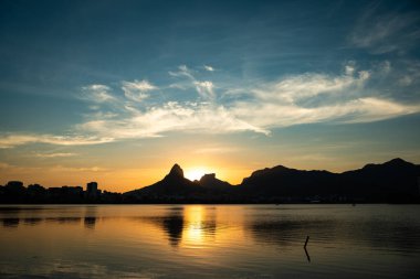 Dağ siluetleri, Brezilya 'nın Rio de Janeiro şehrinde Sunset' teki Lagoa Rodrigo de Freitas 'a yansıdı.