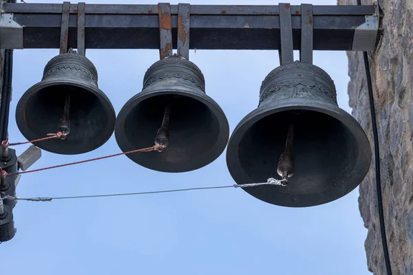 three bells hang on the bell tower of the Christian church. High quality photo