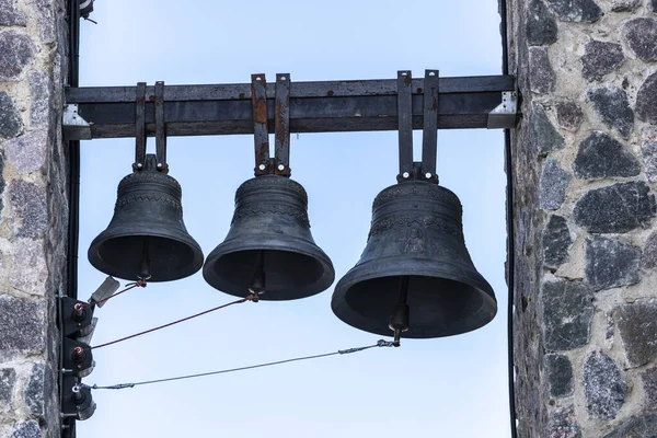 three bells hang on the bell tower of the Christian church. High quality photo