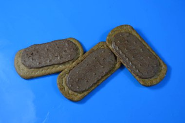 Mavi arka planda çikolatalı bisküviler.