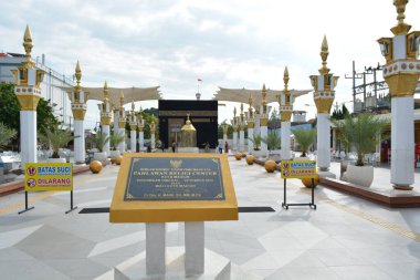 15 Haziran 2025 tarihli editör fotoğrafı Madiun Endonezya uyarı işaretleri ve şemsiyeli bir Kabe kopyasına kadar site plaketinden sütun satırlarına ortalanmış eksen