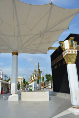 15 Haziran 2025 'te Madiun Endonezya' da Kabe 'nin kopya sütunları ve gergin bir şemsiye örtüsünü gösteren İslami temalı bir plazanın geniş görünümü