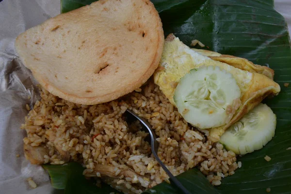 Nasi Goreng 'in muz yaprağında yumurtalı omlet, salatalık dilimleri ve Endonezya sokak kahvaltısı ya da öğle yemeği.