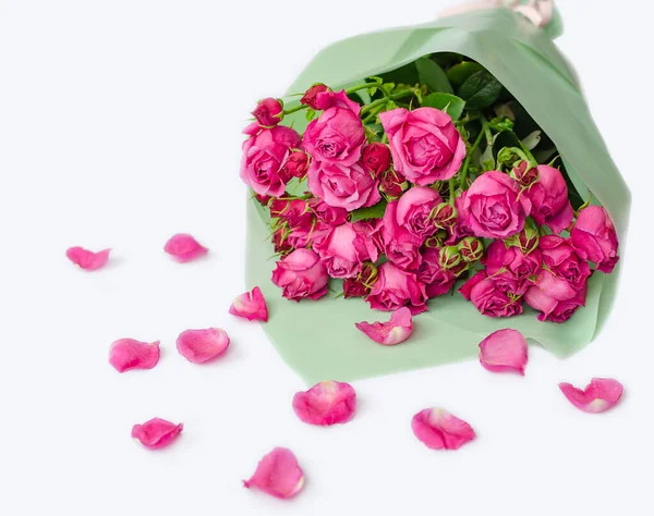 rose in a bouquet with fallen petals on a white background, close-up