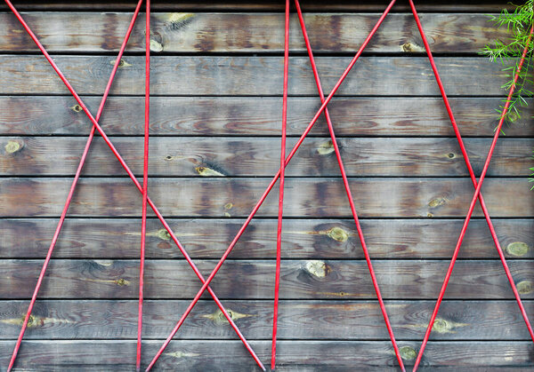 Деревянный фон демонстрирует художественное расположение красных диагональных линий, которые создают поразительный геометрический узор. Этот дизайн придает пространству современный оттенок.