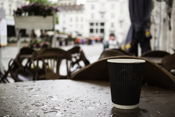 Kaffeetasse auf Straßencafé-Tisch im Regen — Stockfoto