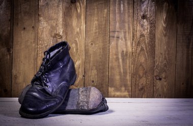 Ahşap zemin üzerinde siyah çizmeler standı