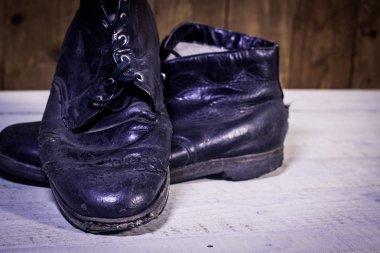 Beyaz ahşap zemin üzerinde bot kırık vintage