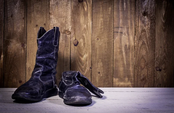 Stare buty złamane stanąć na drewnianej podłodze — Zdjęcie stockowe