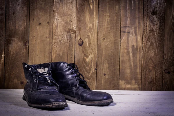 Leather boots stand on wooden floor — Stock Photo, Image