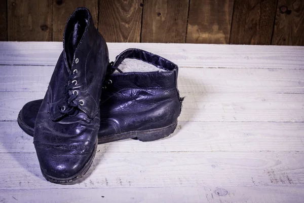 Zdjęcia czarne skórzane buty na drewnianej podłodze — Zdjęcie stockowe