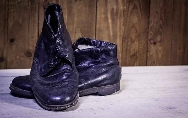 Old boots on wooden floor — Stock Photo, Image