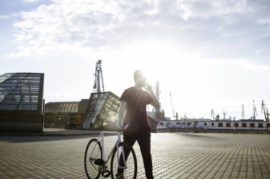 Bisiklet ve speacking telefon ile yürüyen adam 