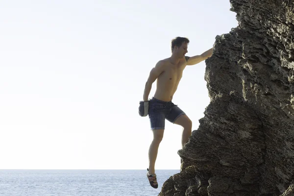 Hombre subiendo a la roca — Foto de Stock