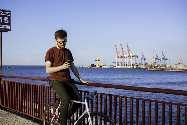 Sakallı adam Bisiklet deniz manzara telefon ile — Stok fotoğraf
