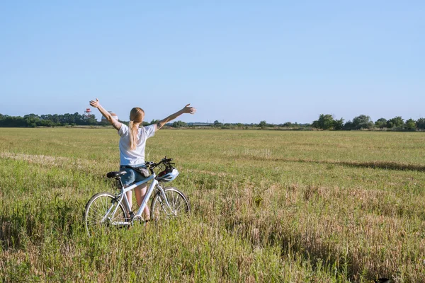 Молода жінка з велосипедними піднятими руками — стокове фото