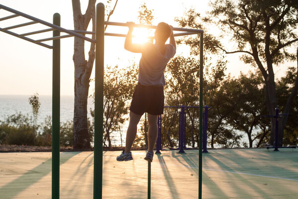 Young male  doing  exercise sunrise bakckground