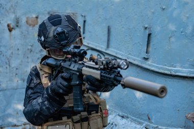 Modern asker siyah multicam üniformalı, tüfekli, şehirli. 
