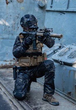 Modern asker siyah multicam üniformalı, tüfekli, şehirli. 