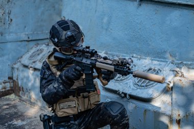 Modern asker siyah multicam üniformalı, tüfekli, şehirli. 