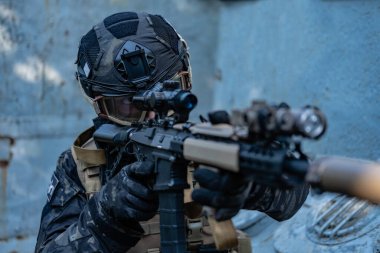 Modern asker siyah multicam üniformalı, tüfekli, şehirli. 