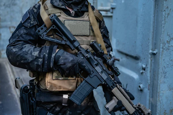 Modern asker siyah multicam üniformalı, tüfekli, şehirli. 