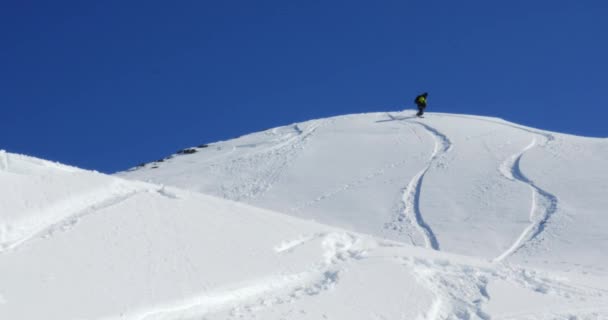 Snowboarder riding down the mountain — Stockvideo