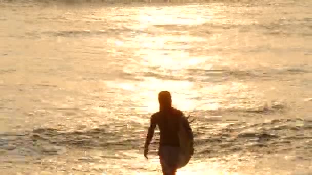 Серфер уходит в океан — стоковое видео