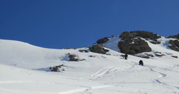 Esqui e snowboarder subindo colina — Vídeo de Stock