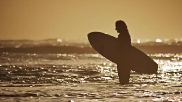 Девушка собирается в океан для серфинга — стоковое видео