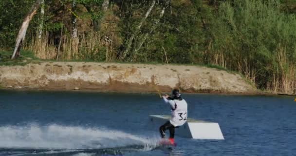 Wakeboarder making a nosepress on slider — Stock Video