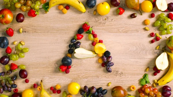 Fruits made letter A. The composition of bright ripe fruits. Alphabet on a table.