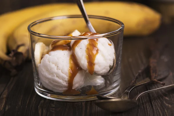 Ice cream scoops with banana slices and caramel sauce