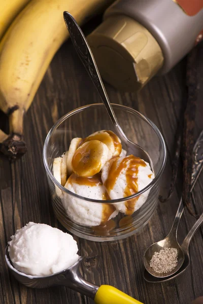 Ice cream scoops with banana slices and caramel sauce
