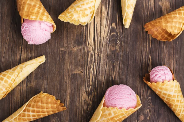 Ice cream in wafel kegels over houten achtergrond — Stockfoto