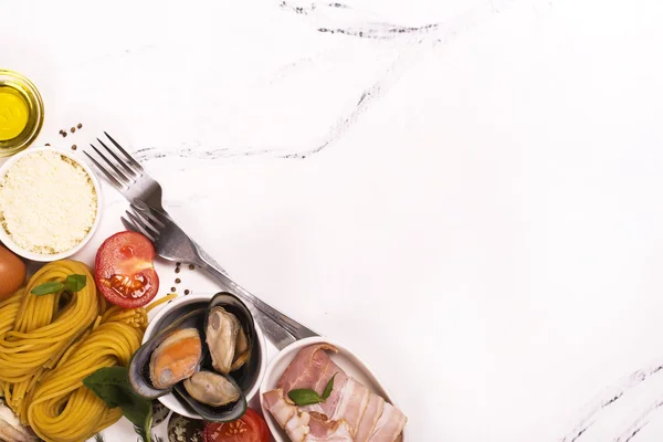 Pasta with ingredients over white marble table — Stock Photo, Image