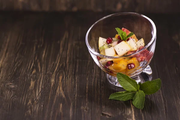 Salada de frutas em tigelas de vidro sobre fundo escuro — Fotografia de Stock