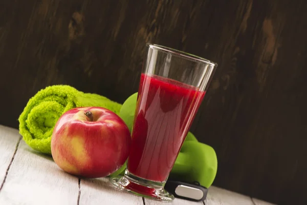 Conceito de fitness ou dieta: halteres, smoothie vermelho fresco, maçã — Fotografia de Stock