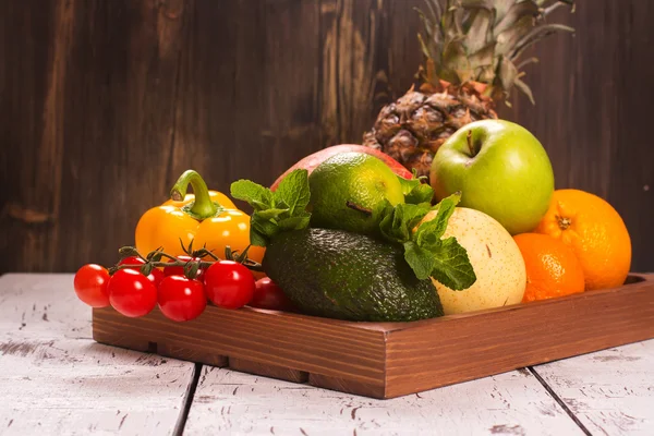 Frutas e legumes frescos em uma bandeja de madeira — Fotografia de Stock