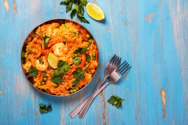 Traditional spanish paella dish with seafood, peas, rice and chicken clipart