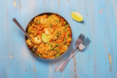 Traditional spanish paella dish with seafood, peas, rice and chicken clipart