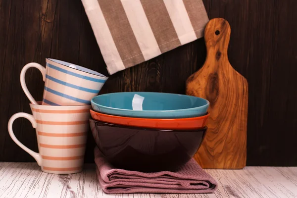Кухонная посуда с салфетками на деревянном столе — стоковое фото