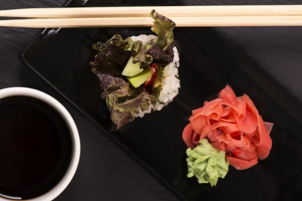 Vegetarisches Sushi rollt über schwarzen Steintisch — Stockfoto