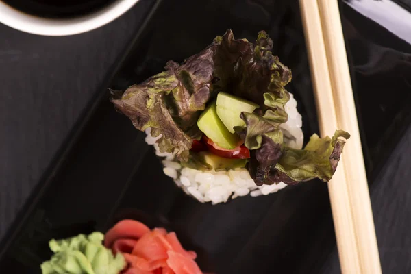 Vegetarisches Sushi rollt über schwarzen Steintisch — Stockfoto