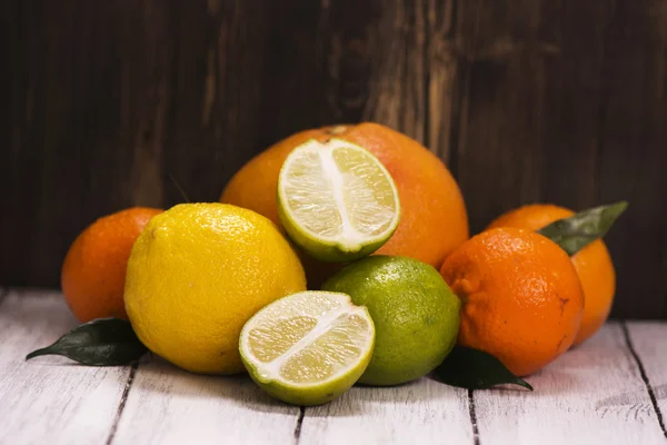 Hög med färska citrusfrukter över trä bakgrund — Stockfoto