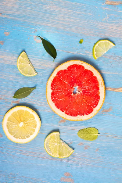 Citrusvruchten segmenten over blauwe tafel — Stockfoto