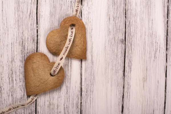 Galletas de jengibre en forma de corazón sobre fondo de madera blanca — Foto de Stock