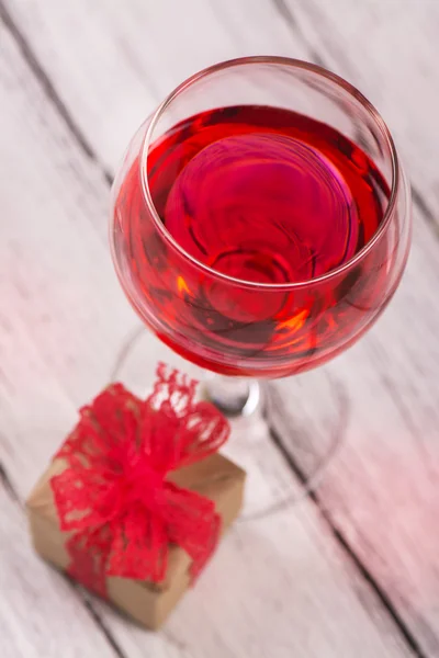 Presentförpackning och glas rosa vin — Stockfoto