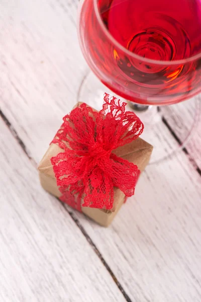 Подарочная коробка и бокал розового вина — стоковое фото