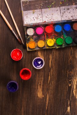 Ahşap masa üzerinde sanatçı araçları